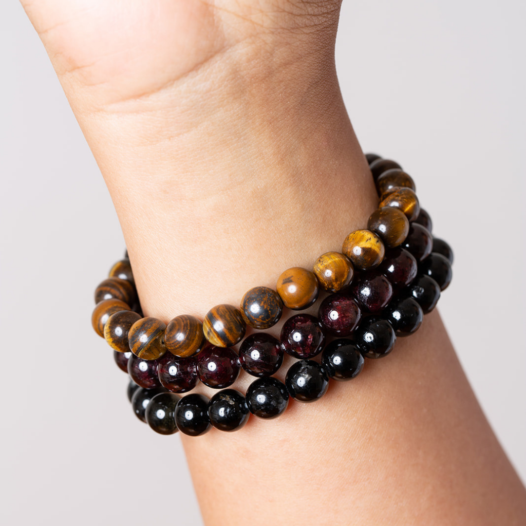women's wrist with Ambarya tiger's eye, garnet and black tourmaline mala beads