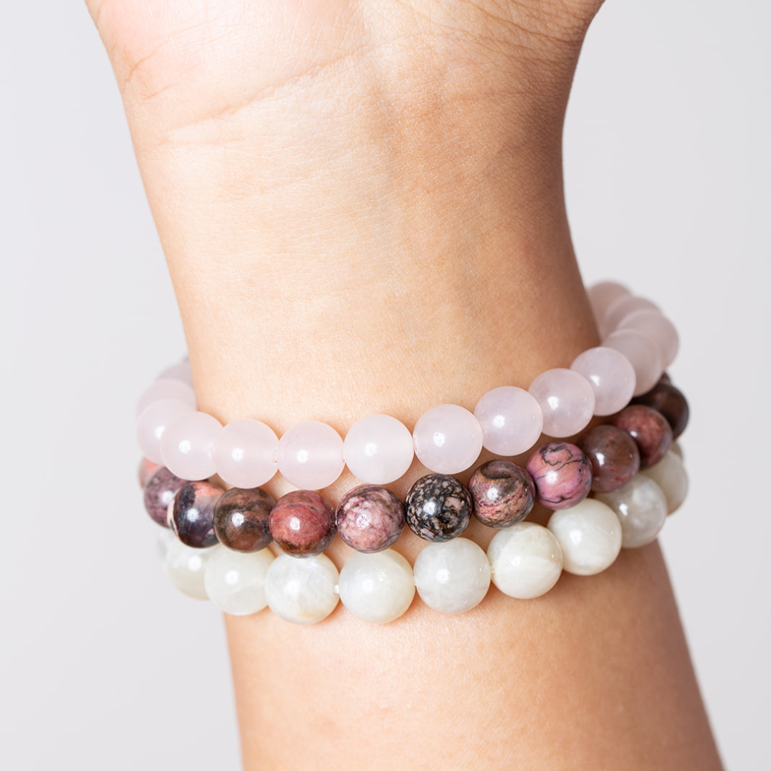 women's wrist with Ambarya rose quartz, rhodonite and moonstone mala beads