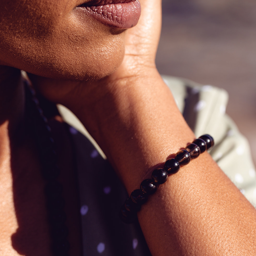 CLose up of woman's wrist wearing Ambarya Release - Smoky Quartz Mala Bead bracelet