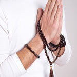 Man wearing Release - Smoky Quartz Mala Bead Necklace wrapped around his hands