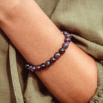 Close up of Amethyst Crystal Mala Bead bracelet on woman's wrist