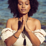 Woman with eyes closed and hands in prayer position wearing Ambarya Willpower - Pyrite Mala Bead Set