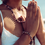 Close up of woman with hands in prayer positionwearing Ambarya Emotional Healing - Rhondonite Mala Bead Set
