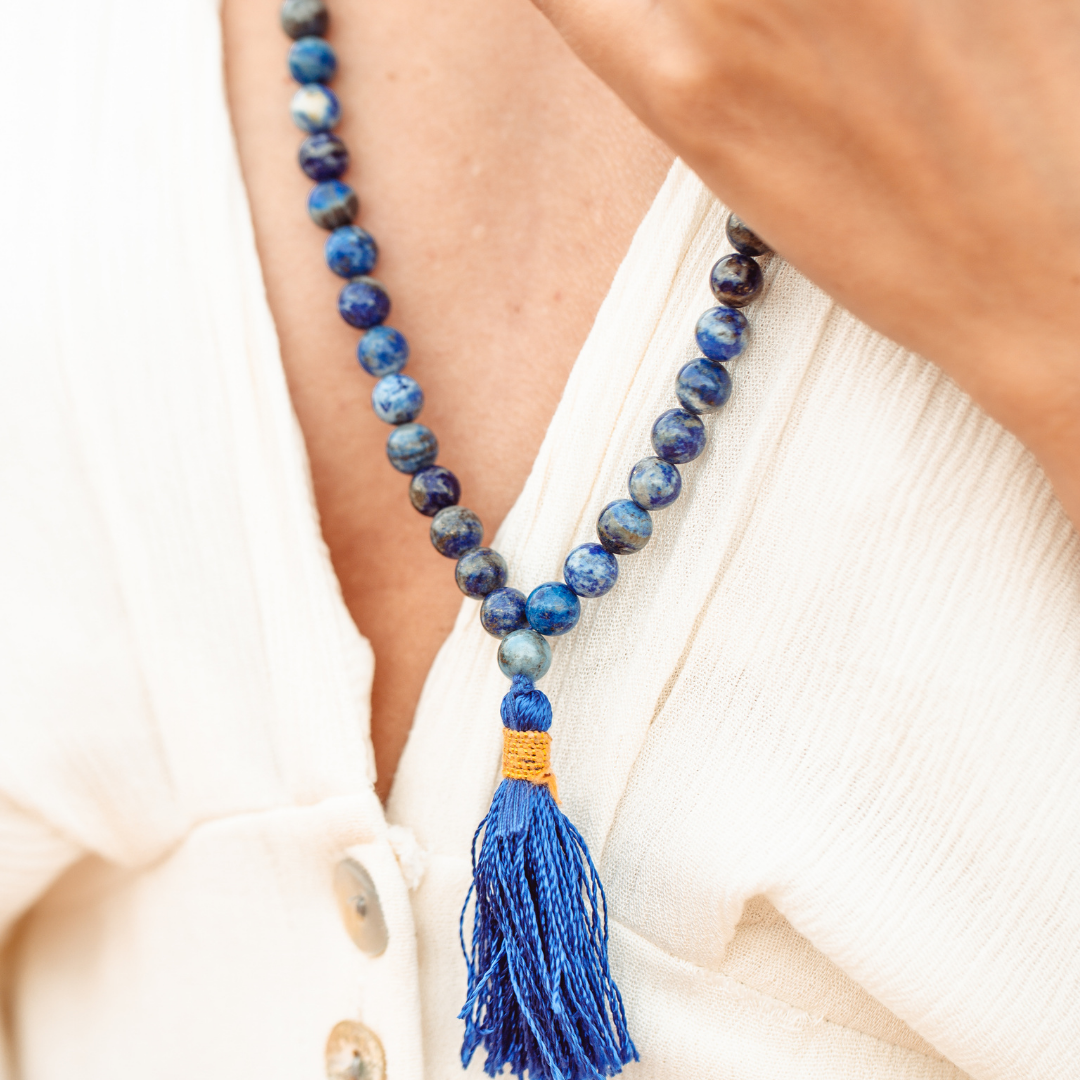 Close up of Ambarya lapis lazuli mala bead necklace around a woman's neck